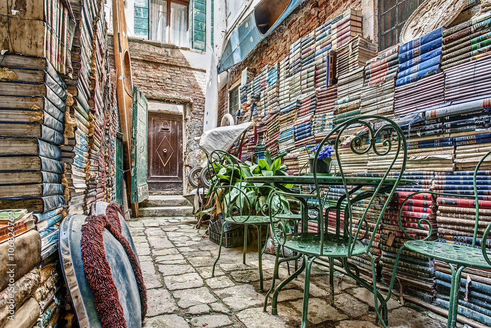 Fototapeta premium Water Logged Books and Magazines await the Next Aqua Alta in just Another Beautiful Back Alley of Venice, Italy