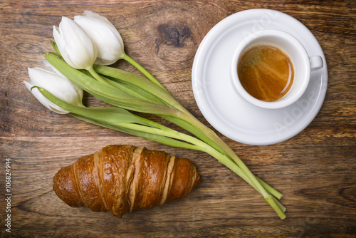 coffee, croissant and three white tulips for spring breakfast
