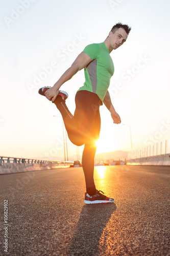 Stretching after jogging on a bridge.