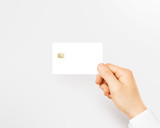 Hand holding blank white credit card mockup isolated. Empty plastic card mock up hold in arm. Clear surface bank card with electronic chip. Debit card concept design presentation template.