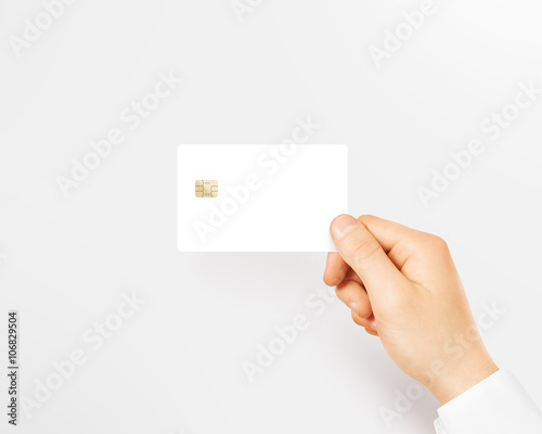 Hand holding blank white credit card mockup isolated. Empty plastic card mock up hold in arm. Clear surface bank card with electronic chip. Debit card concept design presentation template.