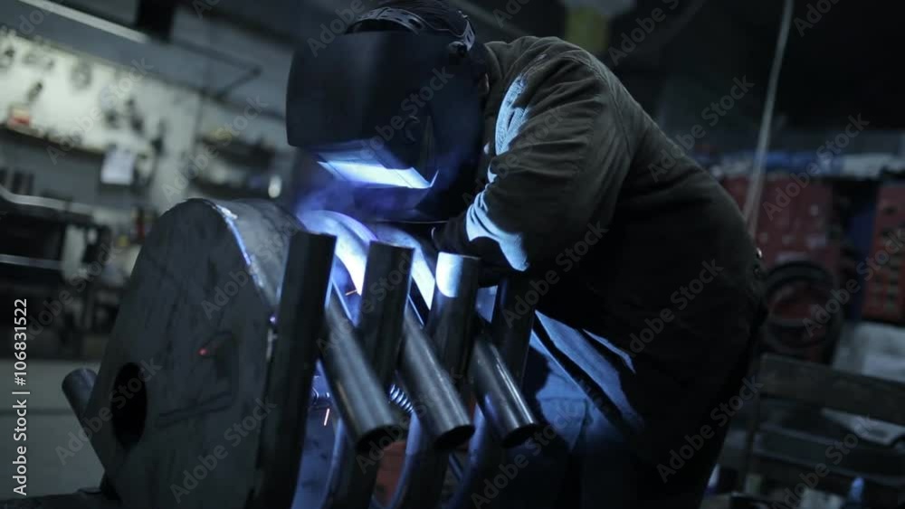 Welder in a protective helmet working on an industrial enterprise Welder in a protective helmet working on an industrial enterprise