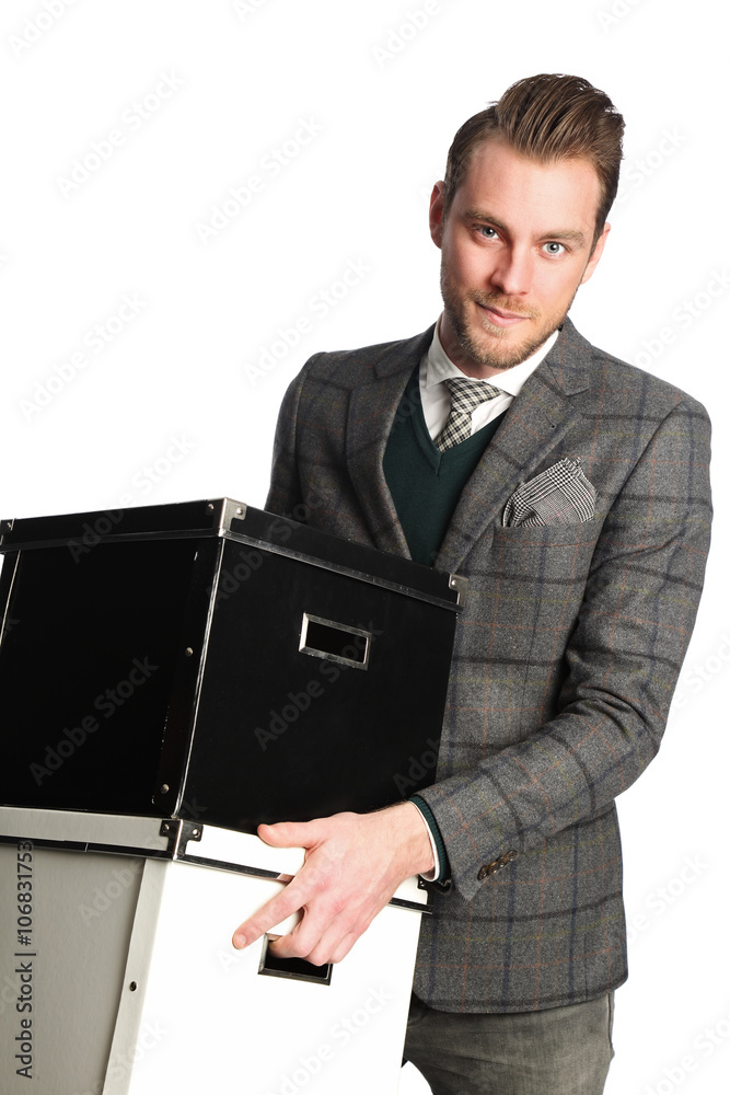 An attractive businessman in his 20s wearing a grey suit and tie, holding boxes. Standing in front of a white background. An attractive businessman in his 20s wearing a grey suit and tie, holding boxes. Standing in front of a white background.