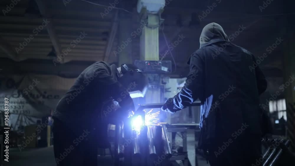 Welder in a protective helmet working on an industrial enterprise Welder in a protective helmet working on an industrial enterprise