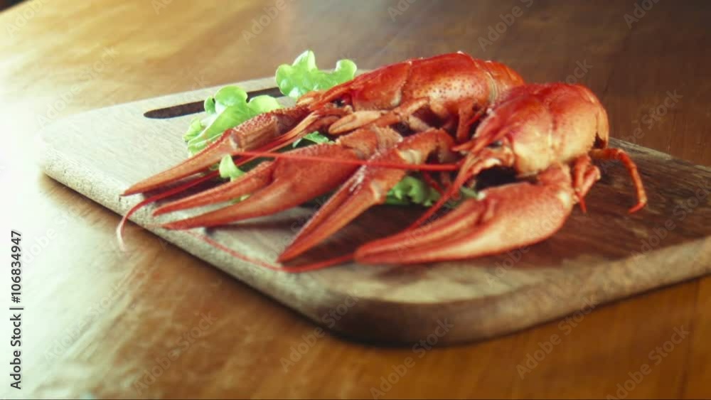 The female puts crayfish of lobsters on a tray on a lettuce leaf The female puts crayfish of lobsters on a tray on a lettuce leaf