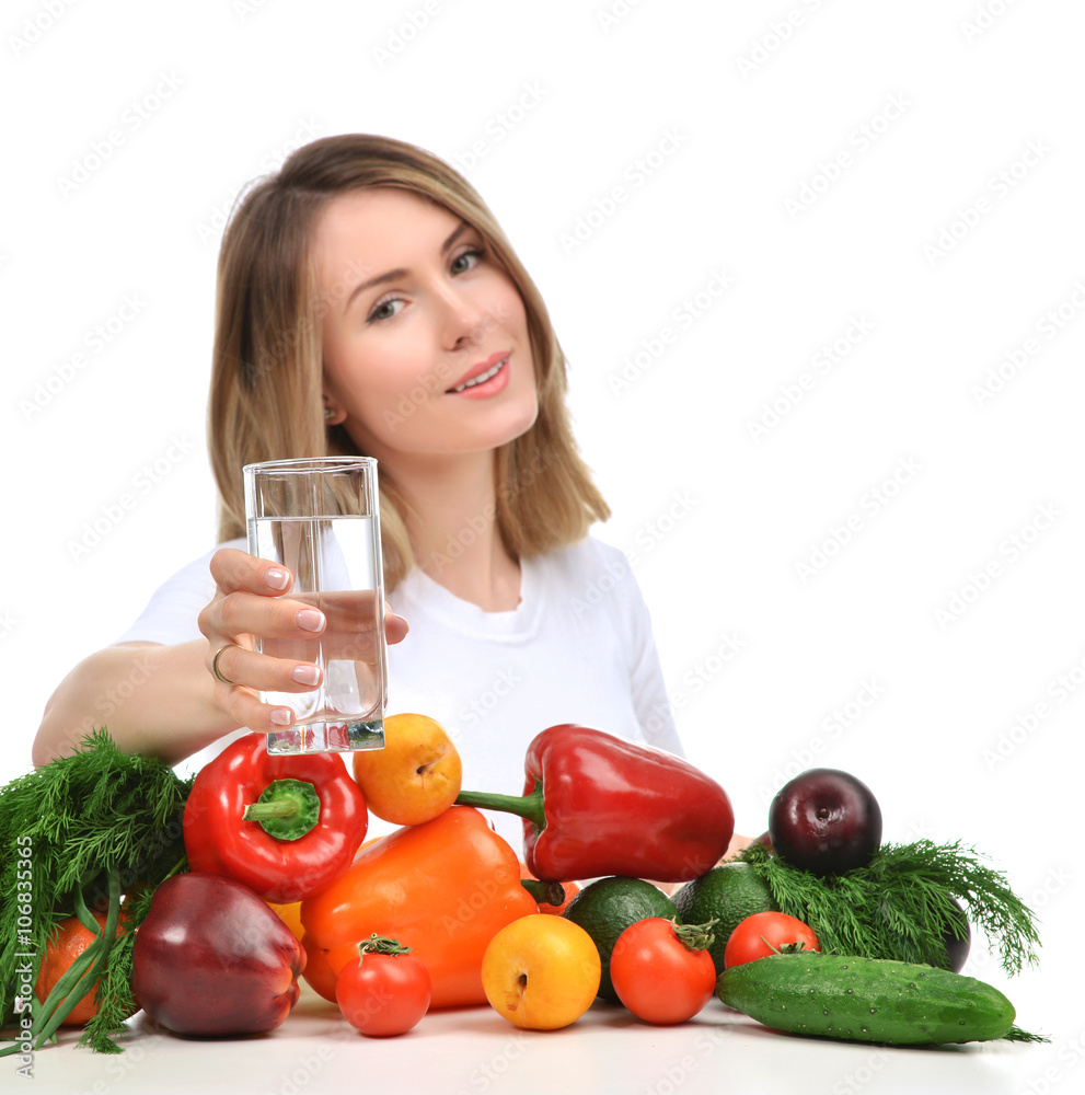 Woman with glass of drinking water and green vegetables and frui Woman with glass of drinking water and green vegetables and frui