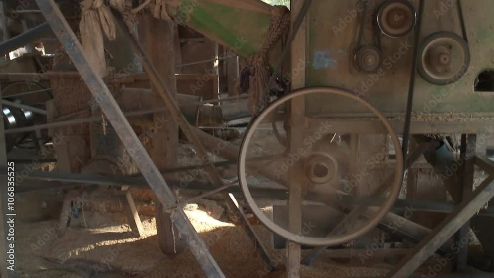 MCU side view of a rice milling machine at work in the Asian countryside MCU side view of a rice milling machine at work in the Asian countryside