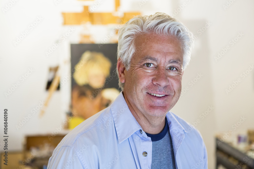 Older Hispanic artist smiling in studio Older Hispanic artist smiling in studio