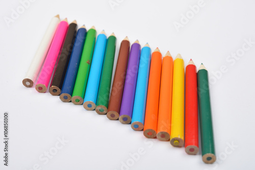 Close up picture of many little colored pencil crayons on white