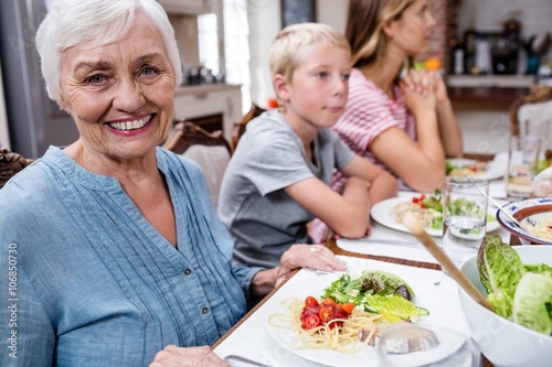Portrait of senior woman having meal with her family