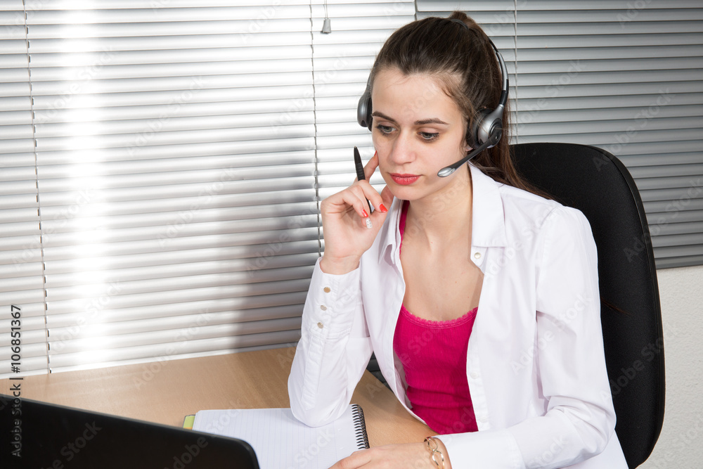 Young businesswoman or secretary working in her Office with a headset, she has a customer pitch Young businesswoman or secretary working in her Office with a headset, she has a customer pitch