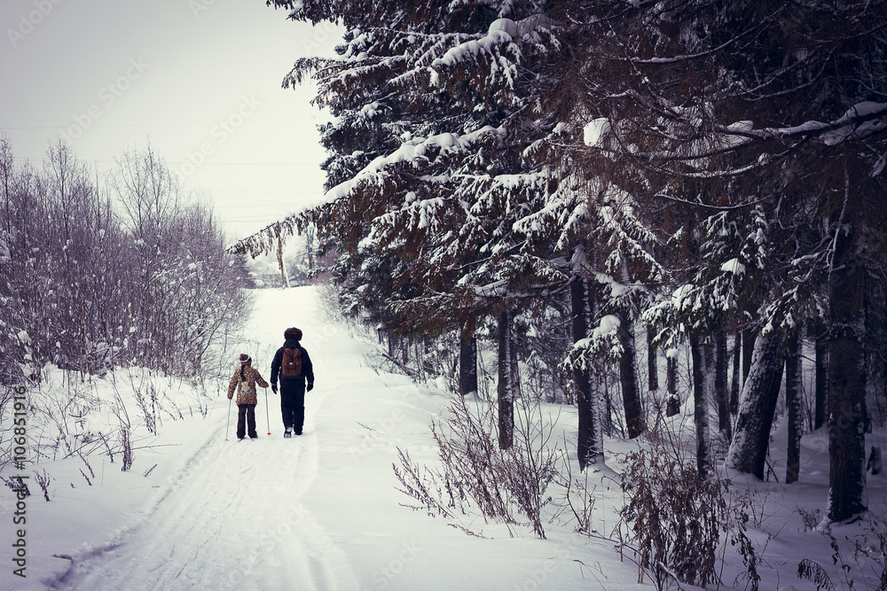 Caucasian father and daughter cross-country skiing on snowy road Caucasian father and daughter cross-country skiing on snowy road