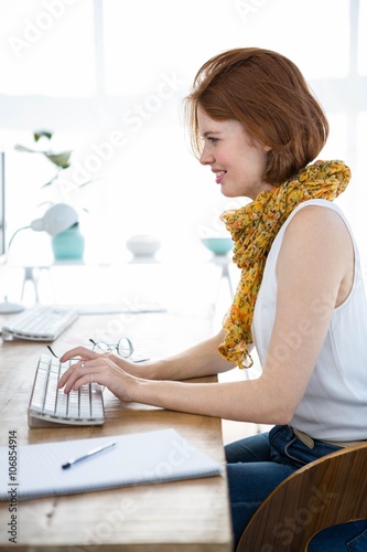 smiling hipster businesswoman typing on her computer © WavebreakmediaMicro