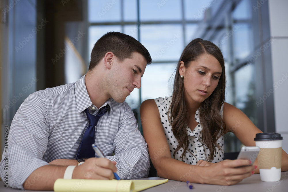 Business people using cell phone in office meeting Business people using cell phone in office meeting