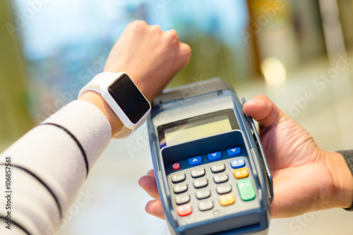 Woman using smartwatch for paying with NFC technology