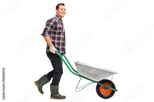 Foto Gardener pushing an empty wheelbarrow