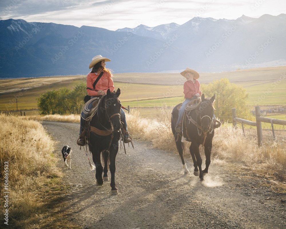Caucasian mother and son riding horses on ranch Caucasian mother and son riding horses on ranch