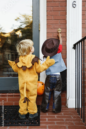Boys in costumes trick or treating together on Halloween photo
