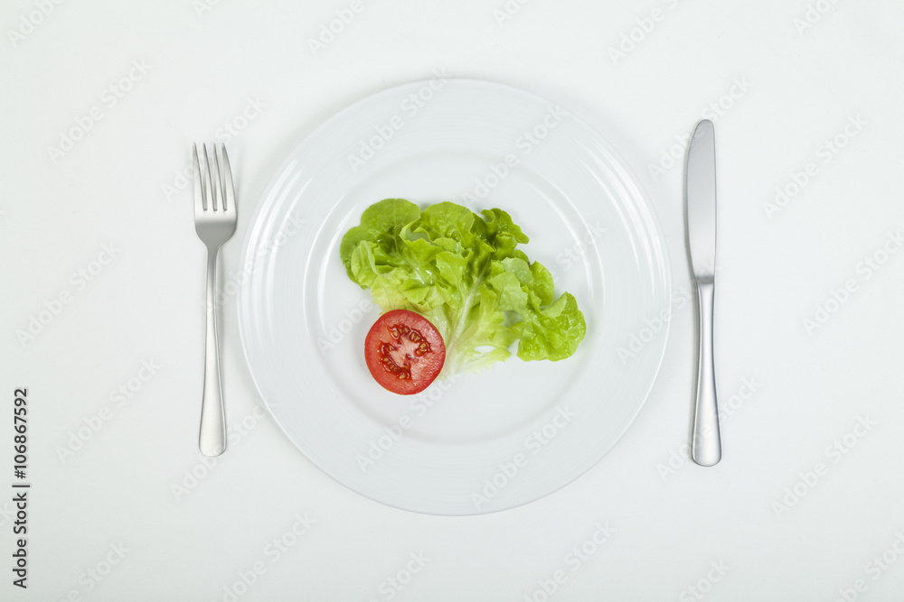 Stück Tomate und Salatblatt auf Teller Stück Tomate und Salatblatt auf Teller