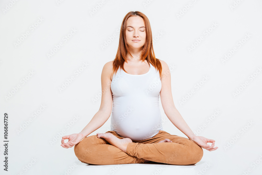 Pregnant woman meditating in lotus position