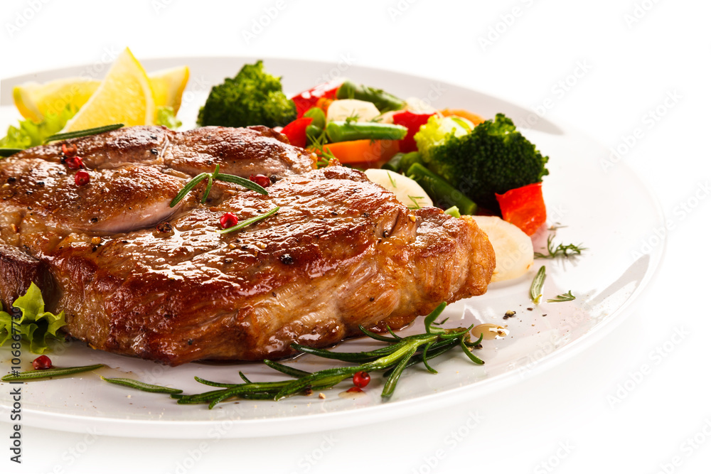 Grilled steak and vegetables on white background