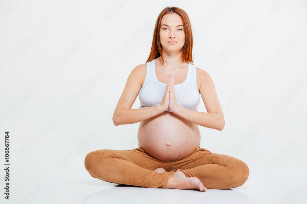 Pregnant woman meditating on the floor Pregnant woman meditating on the floor