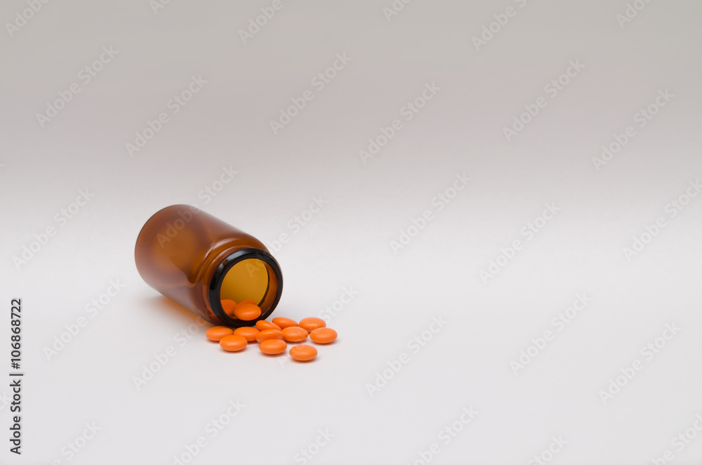 Orange pills scattered on a table