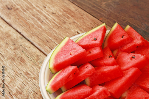 Sliced watermelon on white plate and wooden background