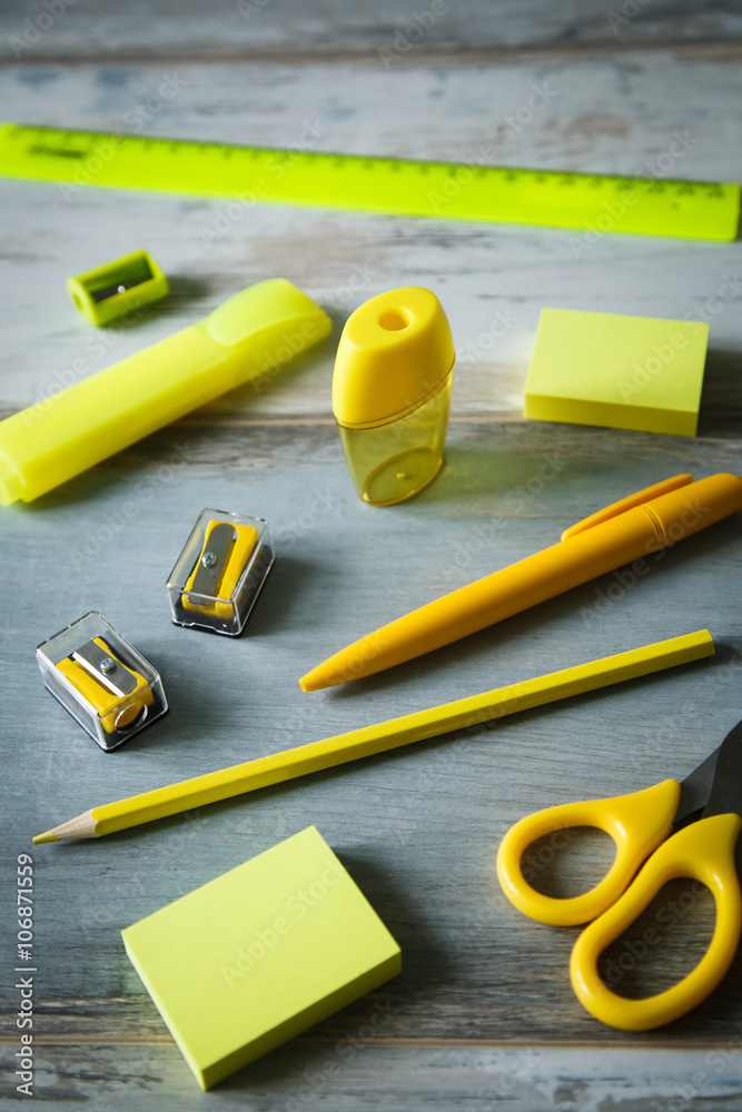 Yellow set stationery objects on wooden table copy space close up

