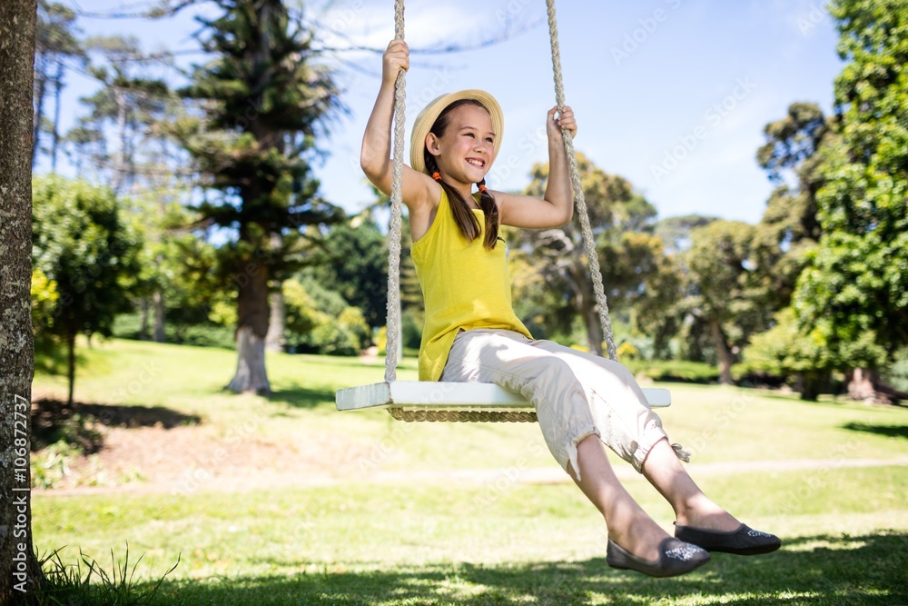 Happy girl sitting on a swing in the park Happy girl sitting on a swing in the park