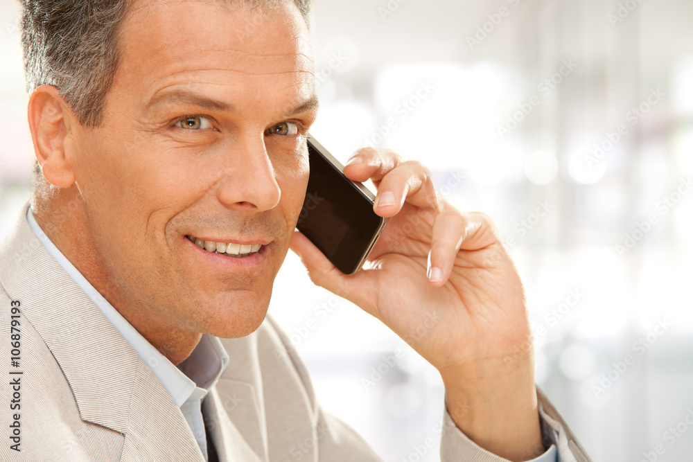 handsome smiling businessman talk on phone at office handsome smiling businessman talk on phone at office