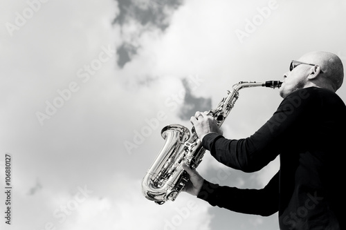 saksofonista-bawic-sie-na-saksofonie-na-niebieskiego-nieba-tle