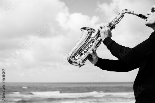 Canvas Print Saxophonist playing on saxophone on blue sky background