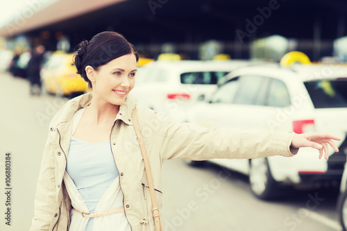 smiling young woman waving hand and catching taxi © Syda Productions