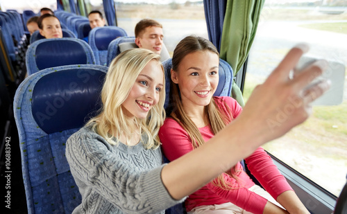 women taking selfie by smartphone in travel bus