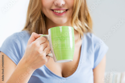 happy woman or teen girl drinking tea from cup