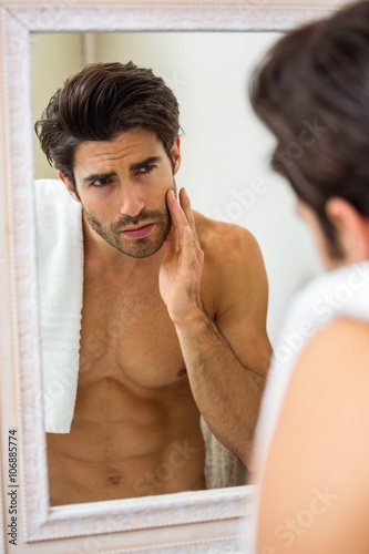 Man checking his skin in bathroom