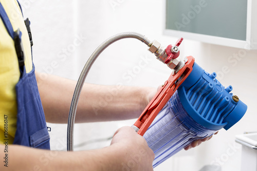 plumber installing new water filter in bathroom