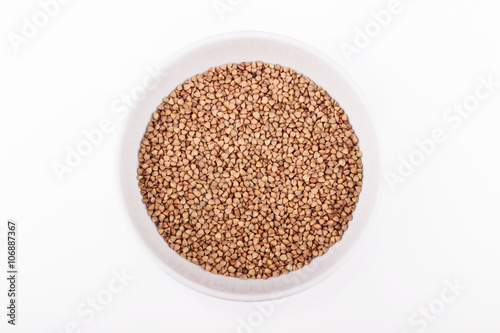 Bowl of buckwheat grains on white background