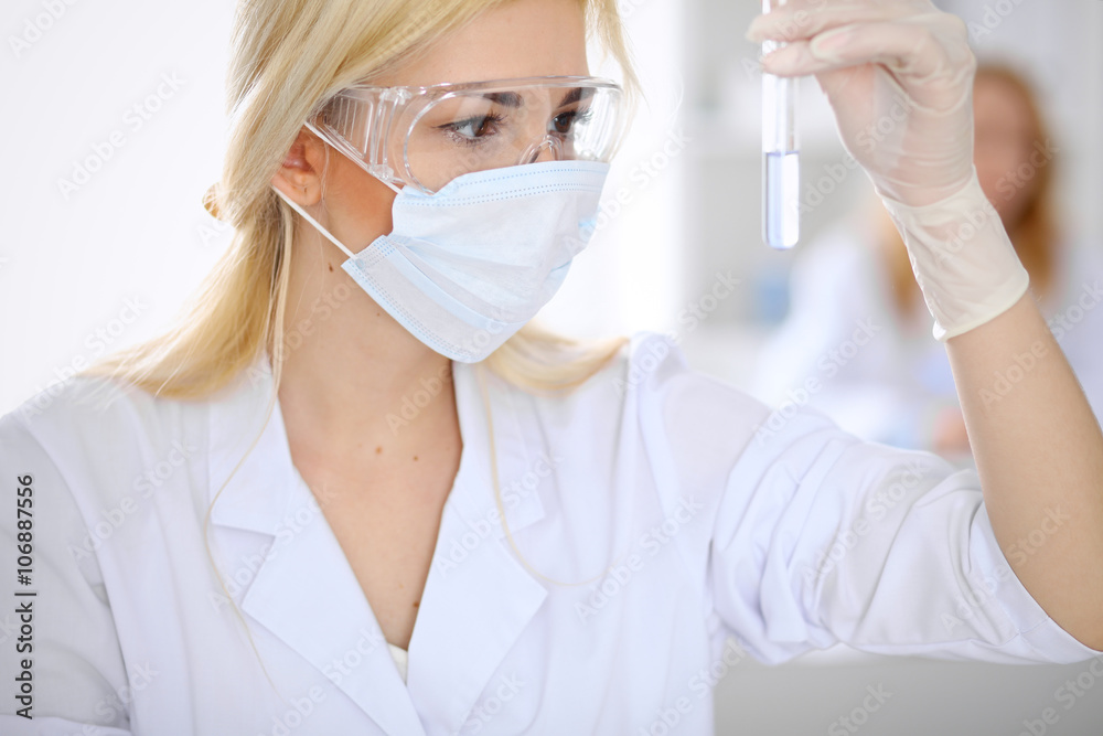 Naklejka premium Female scientific research team with clear solution in laboratory