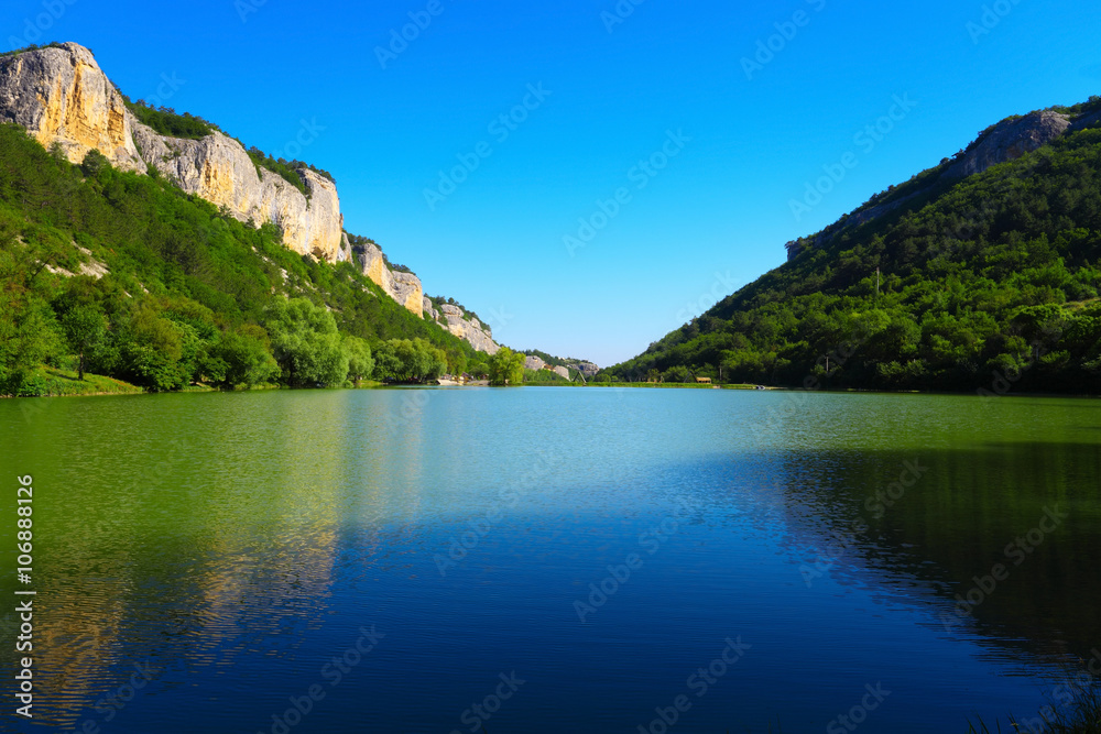 Mountain lake between the rocks and green trees