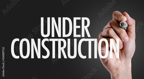 Hand writing the text: Under Construction