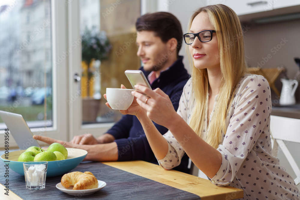 paar sitzt beim frühstück mit laptop und mobiltelefon paar sitzt beim frühstück mit laptop und mobiltelefon