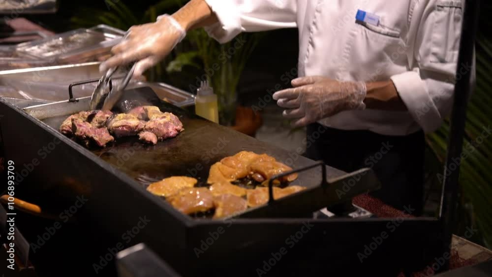 Chefs prepare clams and fish in a restaurant in the open air in the evening. Chefs prepare clams and fish in a restaurant in the open air in the evening.