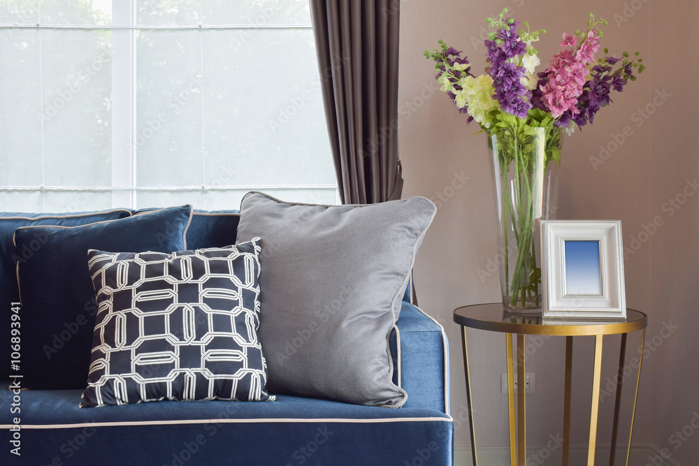 Navy blue modern classic sofa and retro, gray and blue pillows with a