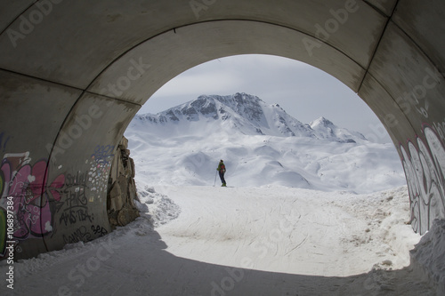 Túnel con un fondo de montañas y mujer esquiadora