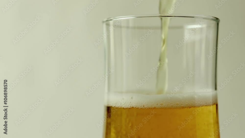 Pour beer into a glass on white background Pour beer into a glass on white background