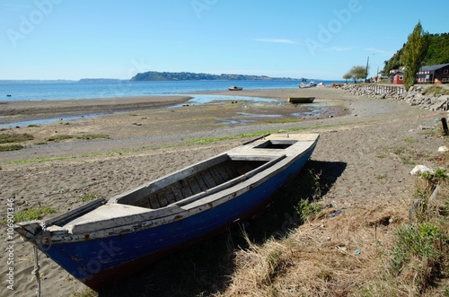 Close-up of a little rowing boat at a beach in Achao with low tide