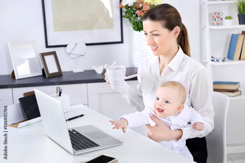 Businesswoman with baby boy working from home using laptop Businesswoman with baby boy working from home using laptop