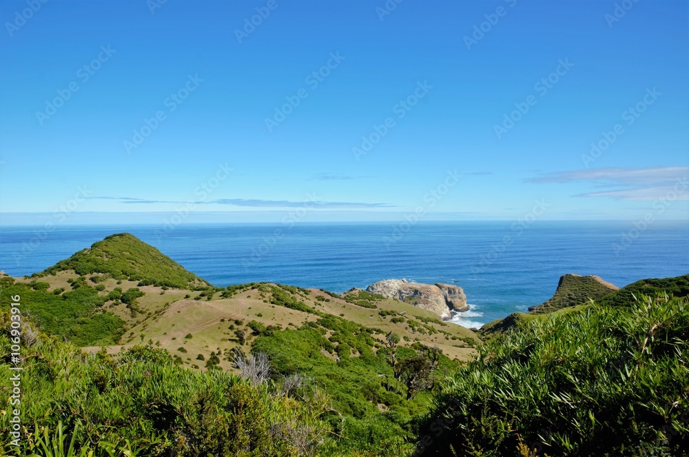 Coastal view onto the Muelle de las Almas with a clear blue sky and green hills